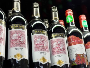 Mağazada çeşitli kırmızı şarap şişeleri sergileniyor..