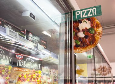 Çeşitli paketleme seçenekleriyle süpermarket koridorunda dondurulmuş pizza görüntüsü.