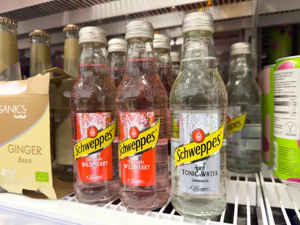 Schweppes içecek şişeleri rafta tonik su ve yaban mersini aromalı.