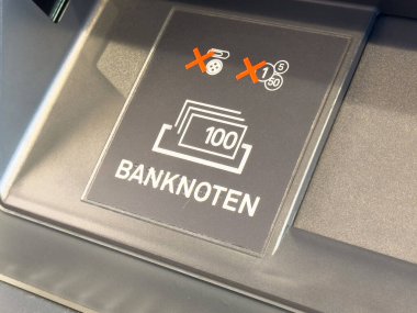Para mevduat karşıtı tabelasıyla ATM para yuvasına yakın çekim.