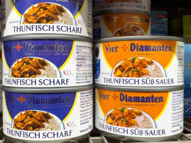 Assorted german canned tuna varieties on grocery shelf. clipart