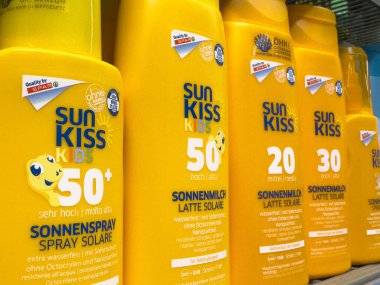 Parlak sarı şişelerde çeşitli spa puanları olan güneş kremi ürünleri seçimi.