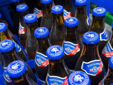 Sandıkta mavi kapaklı puntigamer bira şişelerine yakın çekim.