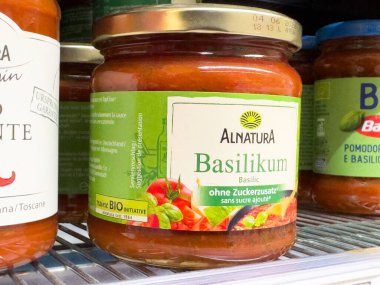 Rafta doğal malzemelerle dolu organik fesleğen sosu kavanozu..