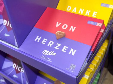 Vitrinde kalp şeklinde çikolata olan Milka Pralines kutusu.