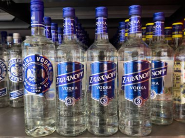 Rafta farklı marka ve etiketleri gösteren çeşitli votka şişeleri var..