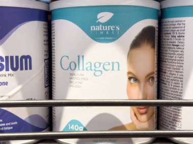 Mağazada kadın beyaz yüzlü kolajen takviyesi.