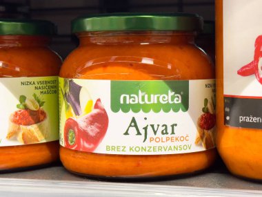 Dolapta biber ve patlıcan grafikli Ajvar sos kavanozu.