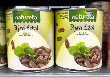 Süpermarket vitrininde yeşil yapraklı konserve kahve çekirdekleri.