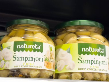 Rafta yeşil kapaklı kavanozlarda mantar turşusu..