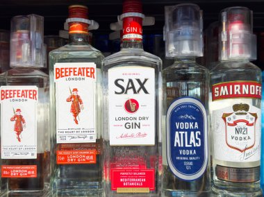 Çeşitli bira şişeleri cin, saksafon, sek cin ve rafta sırıtık votka..