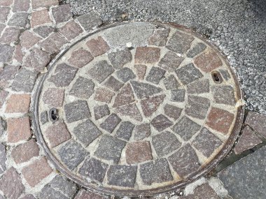 Dökümlü kaldırımda yuvarlak kaldırım kapağı..