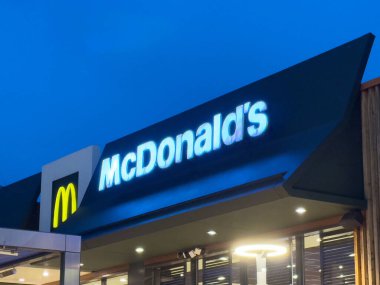 Geceleri McDonald 's restoranının dış tarafında aydınlık logo var..