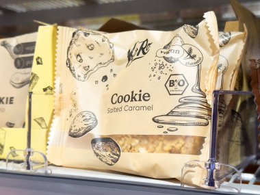 Salted caramel vegan cookie in eco-friendly packaging on store shelf. clipart