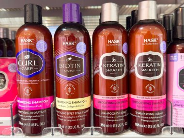 Hask hair care products display: curl care, biotin boost, keratin smooth shampoo bottles. clipart