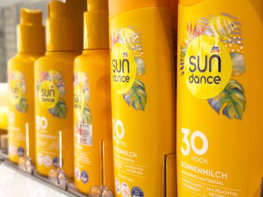 Güneş kremi şişeleri açık sarı ambalajda sergileniyor..
