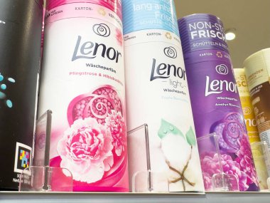 Assorted lenor fabric softener bottles in vibrant colors on store shelf. clipart