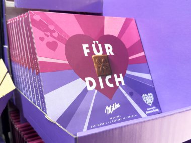 Kalp tasarımı ve mor ambalajlı Milka çikolatalı hediye kutusu.