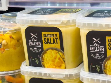 Süpermarket vitrininde kartoffelsalat paketleme.