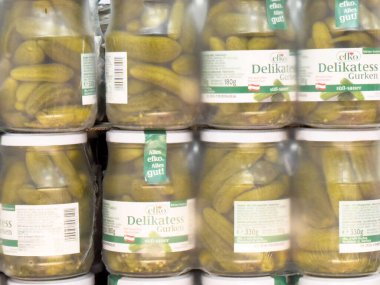 Doldurulmuş turşu kavanozları etiketlerin ve içindekilerin yakın çekim görüntüsüyle depolanmış raflarda..