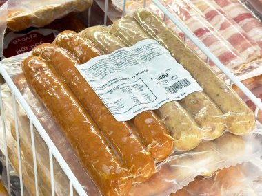 Süpermarket rafında vakum yalıtımlı paketlerde çeşitli sosisler..