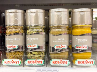 Süpermarketin rafında dört baharat kavanozu: Çemen, kakule, kimyon, zerdeçal.