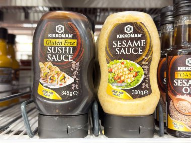 Gluten-free sushi sauce and sesame sauce bottles on grocery shelf. clipart