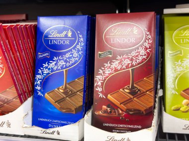 Süpermarket koridorunda çeşitli lindt çikolataları sergileniyor.