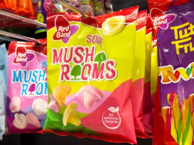 Rafta kırmızı bantlı renkli ekşi mantar jelibonları var..