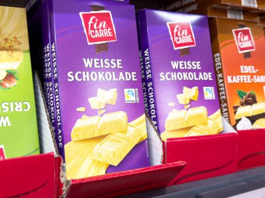 Fin carre beyaz çikolata sergisi süpermarket koridorunda.