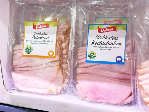 Süpermarket vitrininde dilimlenmiş hindi ve jambon seçimi.