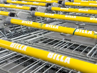 Otoparkta markalı sarı alışveriş arabaları var..