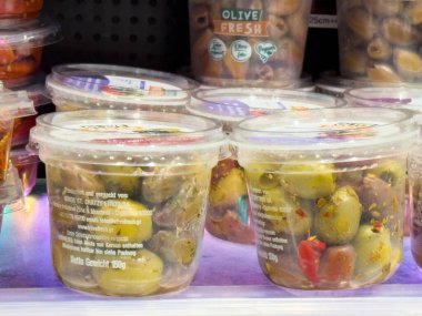 Market koridorunda çeşitli zeytin kapları sergileniyor.