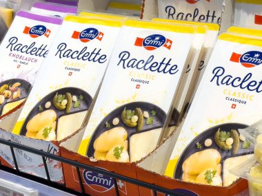 Süpermarketin soğutmalı bölümünde sergilenen emmi raclette peynir ürünlerinin çeşitliliği.