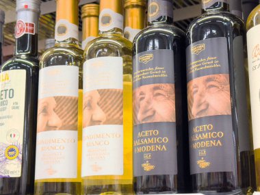İtalyan balzamik sirkesi ve beyaz baharat şişeleri rafta..