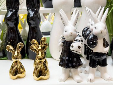 Raflarda seramik ve altın tavşan heykelcikleri sergileniyor.