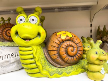 Renkli seramik salyangoz heykeli ve sevimli bir gülümseme tasarımı var..