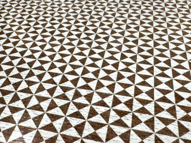 Kahverengi ve beyaz geometrik üçgen desenli tahta yüzey dokusu.