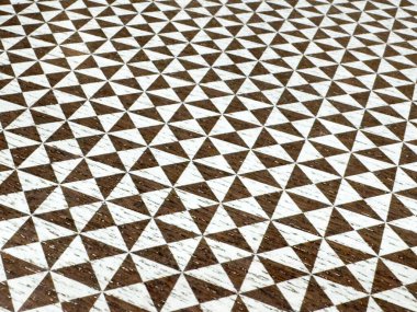Kahverengi ve beyaz geometrik üçgen desenli kumaş dokusu.