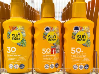 Sarı güneş kremi şişeleri. Parlak bir ekranda 30 ve 50 'den fazla..