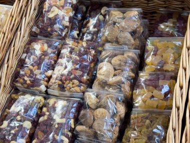 Örülmüş sepetlerde şeffaf ambalajda çeşitli kurutulmuş meyve ve fındıklar..
