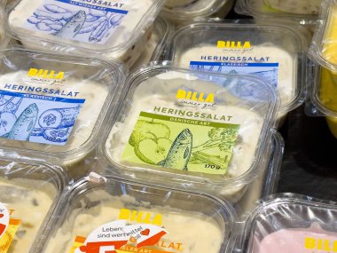 Çeşitli paketlerde billa burada, Alman market vitrininde, bir tür ringa balığı salatası..