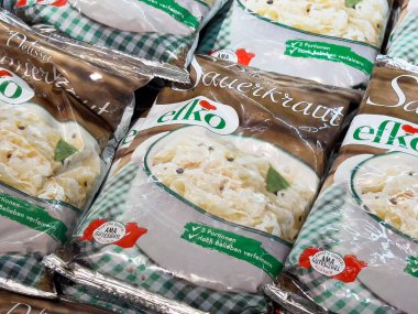 Yeşil kareli tasarımı ve kaliteli mührü olan paketlenmiş lahana turşusu.