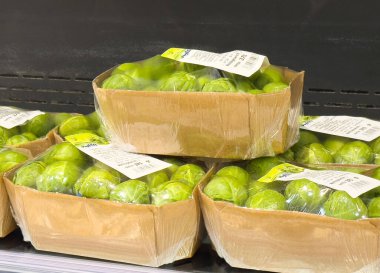 Kahverengi karton kutularda taze Brüksel lahanaları sergileniyor..