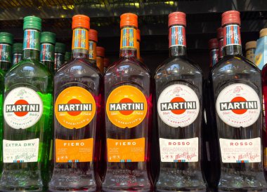 Çeşitli martini aperatifleri sergileniyor: ekstra sek, fiero, rosso şişeleri rafta..