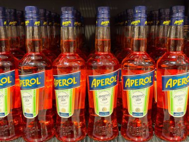 Aperol bottles arranged on store shelf for sale. clipart