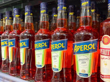 Likör dükkanında renkli aperol şişeleri, canlı etiketler ve ambalajlarla sergileniyor..