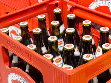 Bira fabrikası logosu mühürlü kırmızı plastik kapta bir kasa bira şişesi..