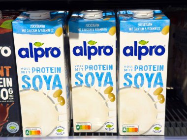 Alpro soya protein milk cartons with calcium and vitamin d2 on store shelf. clipart