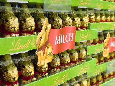 Yeşil ambalaj vitrininde altın folyolu çikolata tavşancıkları.